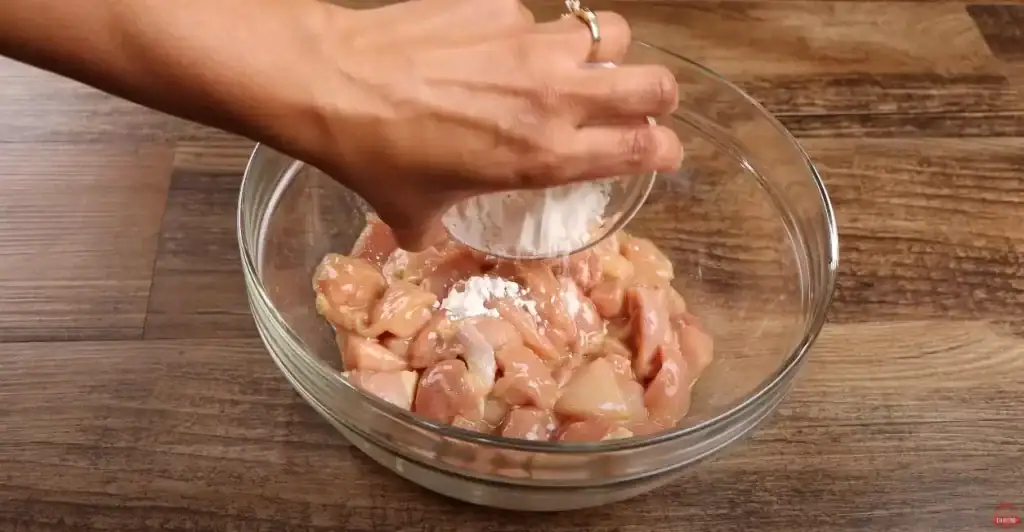 adding the cornstarch to the chicken 